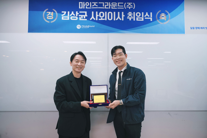 Min Hwan-ki, CEO of Maines Ground (right), delivers his inauguration plaque to outside director Kim Sang-kyun at the inauguration ceremony held in the conference room of Maines Ground headquarters on the morning of the 23rd. (Photo = Courtesy of Minds Ground)