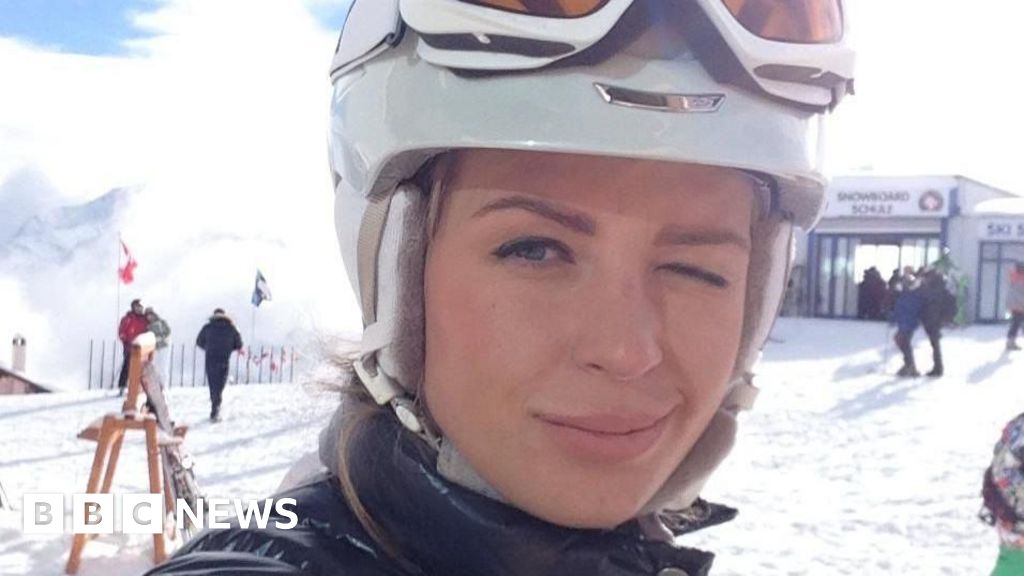 Ekaterina Zhdanova on the ski slopes, winking at the camera.